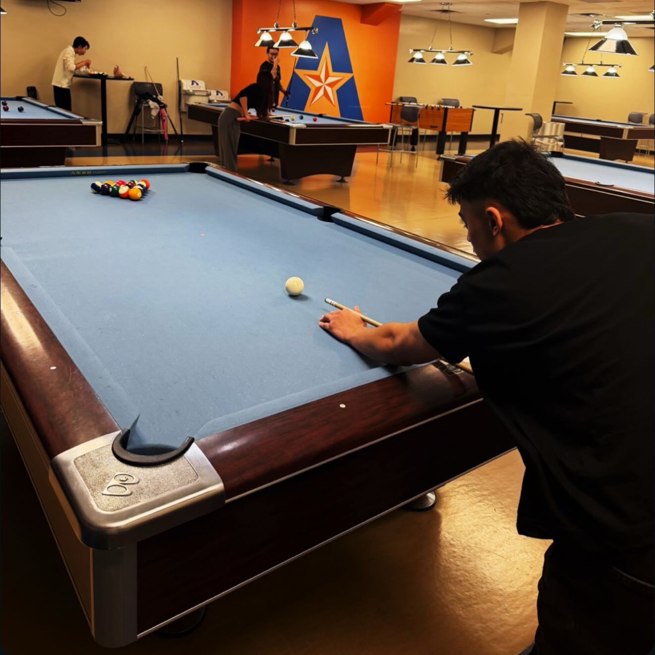 Swopnab lining up a shot at a pool table